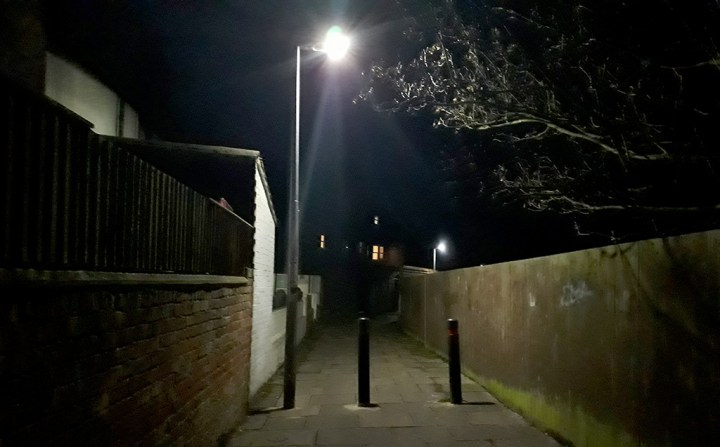 Entrance to the Cuttleby passageway, receding into back walls, lit by a single streetlight in the foreground